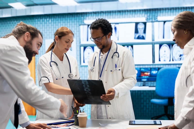 Healthcare professional reviewing medical device performance data with a patient in a clinical setting